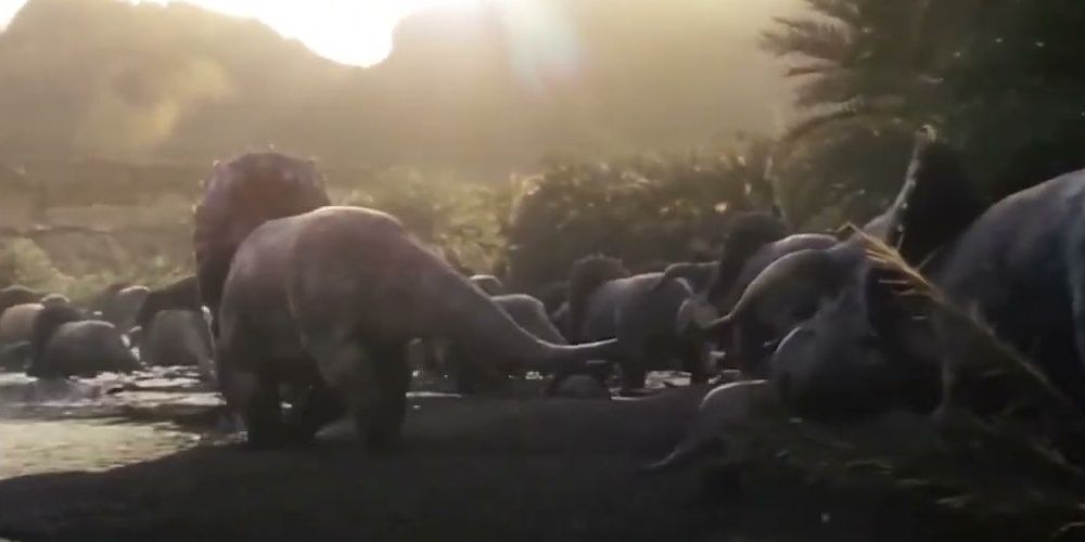 A herd of Nasutoceratops walking pass a river in Jurassic World: Dominion.
