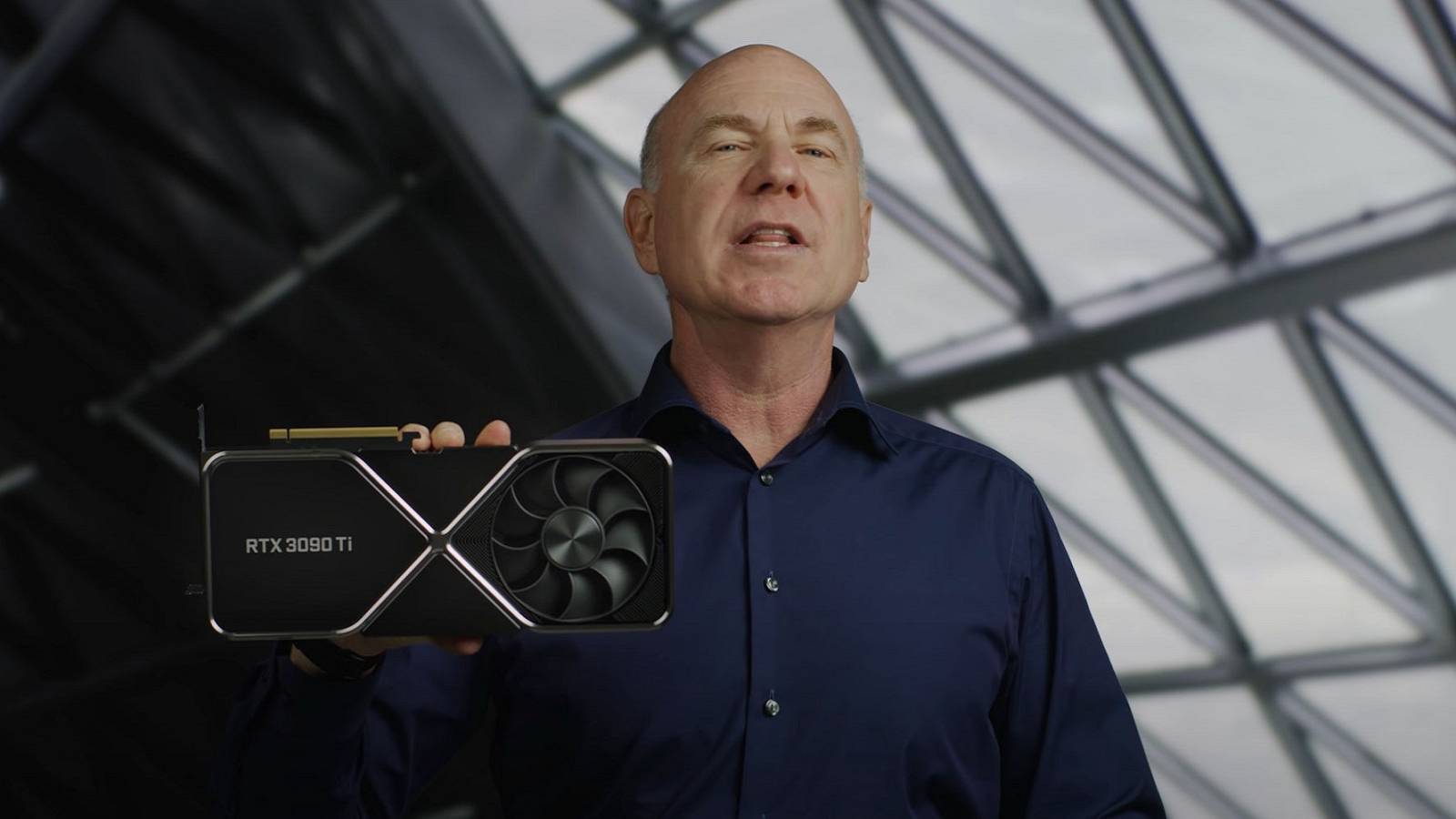 Photo showing someone holding up an Nvidia RTX 3090 Ti graphics card.