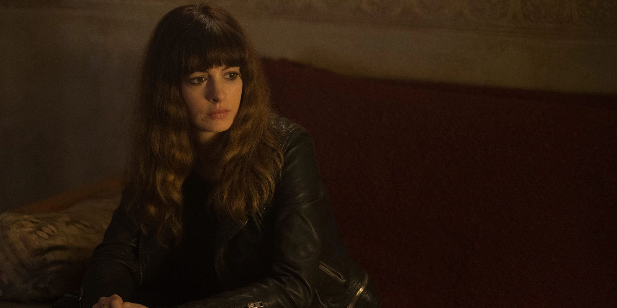 Anne Hathaway sitting on a couch in Colossal