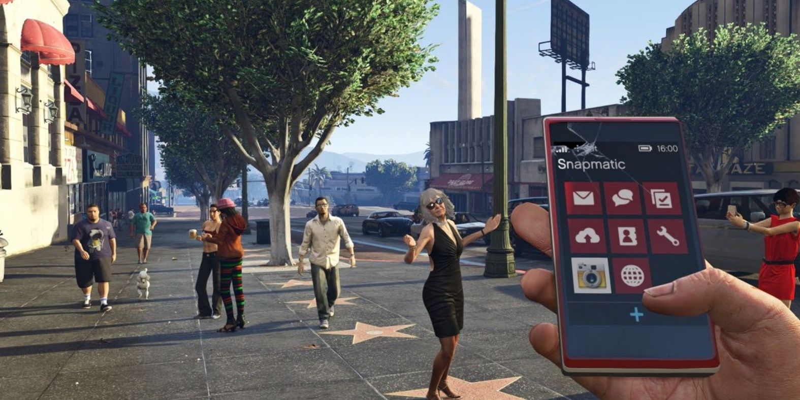 A player looking at their cellphone on the sidewalk in Grand Theft Auto V