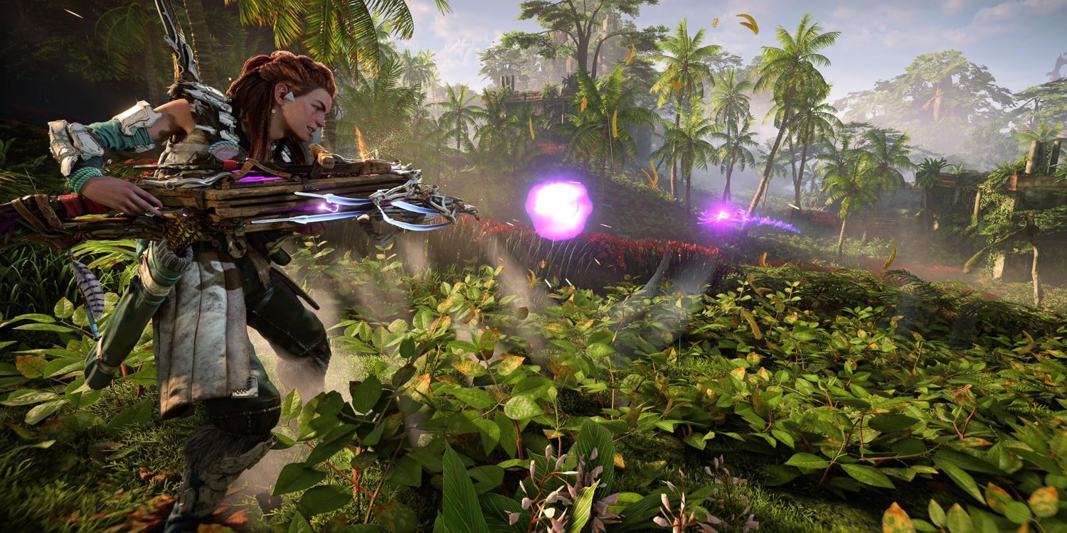 aloy in green and white metal armor holding a heavy crossbow while firing purple glowing bolts toward distant palm trees