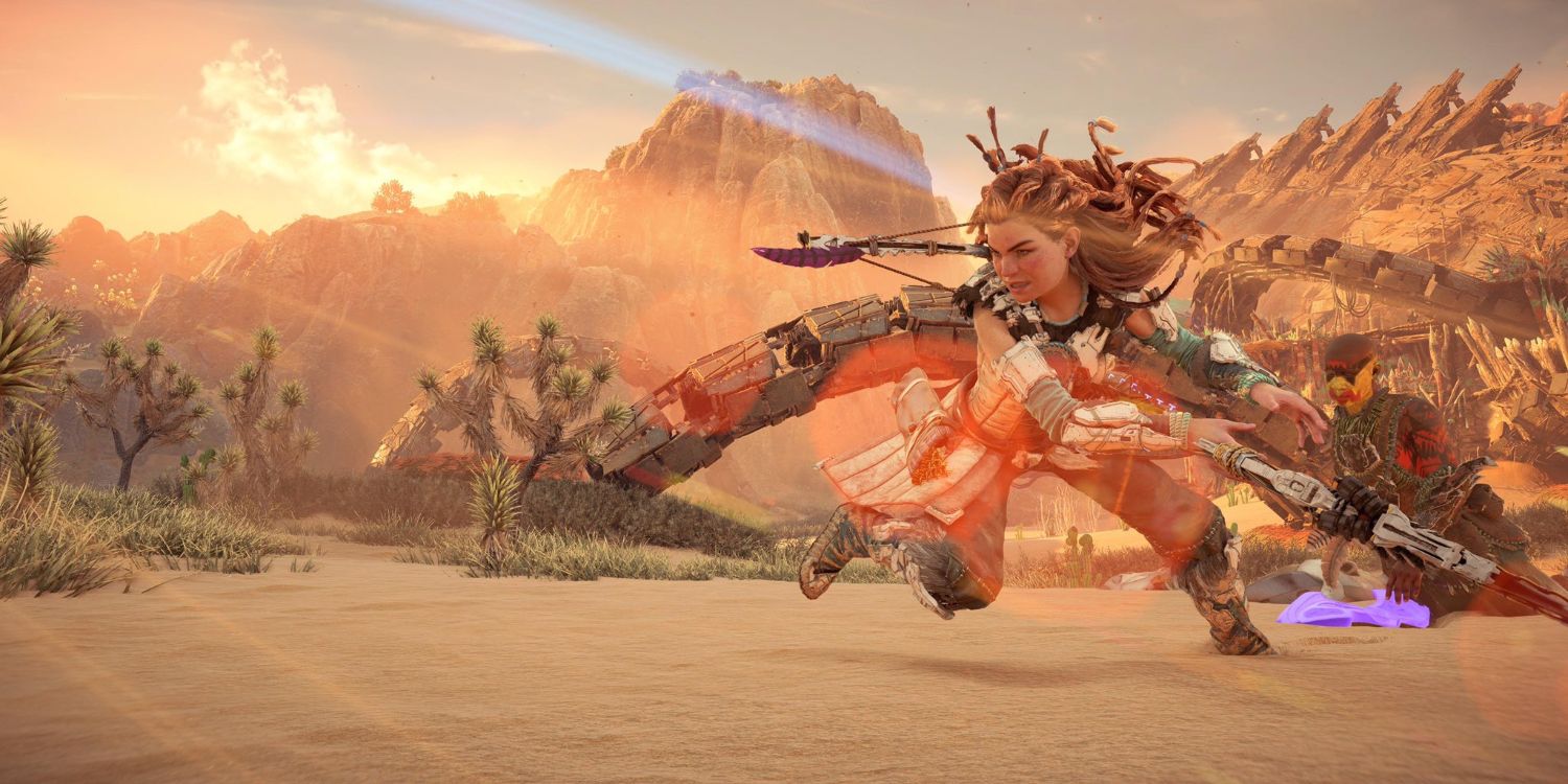 aloy standing in a desert swinging her spear in a large arc while an enemy soldier kneels on the ground behind her