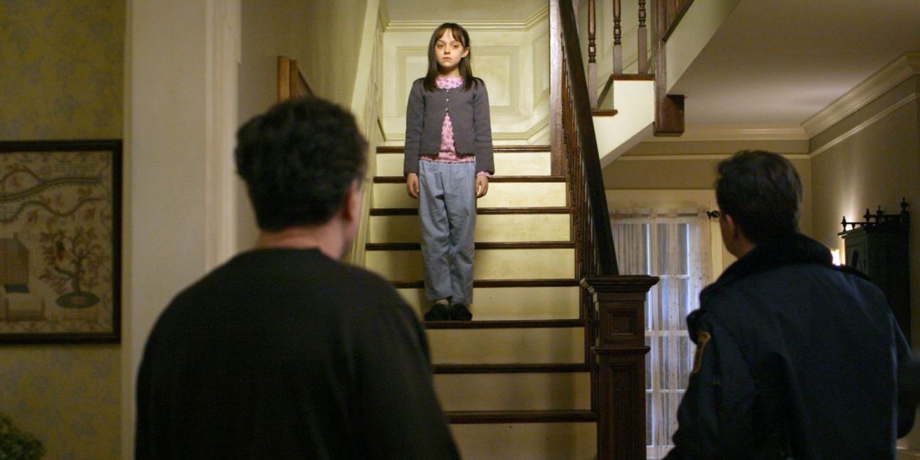 Dakota Johnson as Emily Calloway standing on stairs in Hide and Seek