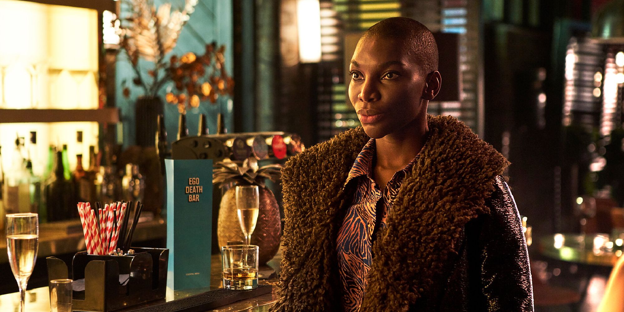 Michaela Coel as Arabelle with a shaved head at a bar