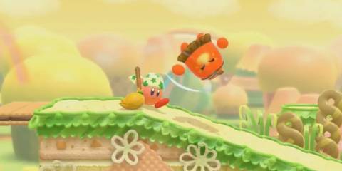 Kirby hitting an enemy with a broom in Kirby Star Allies