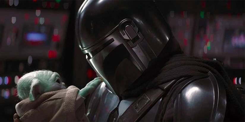 Mando holding Grogu in The Mandalorian