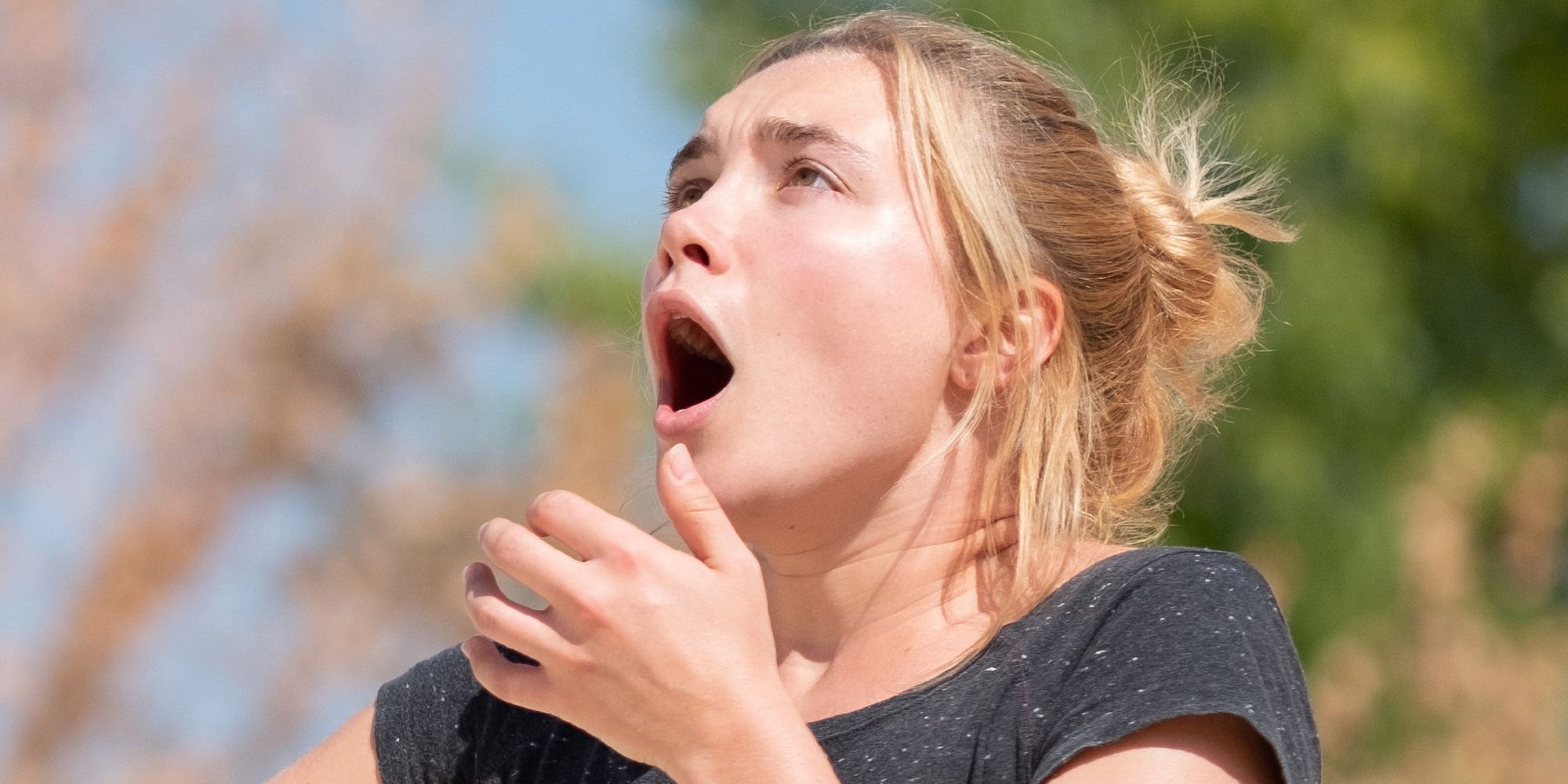 Florence Pugh as Dani staring up at something scary in Midsommar