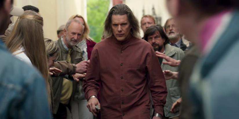 Ethan Hawke as Arthur Harrow walking through a crowd of his followers