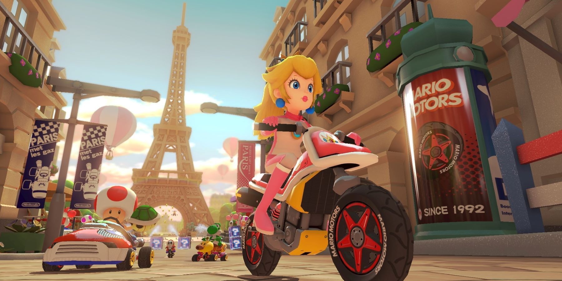 Пич, Жаба, Йоши и Застенчивый Гай мчатся по Парижской набережной в Mario Kart 8 Deluxe.