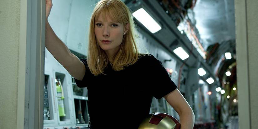 Pepper Potts in Tony's lab holding the Iron Man helmet