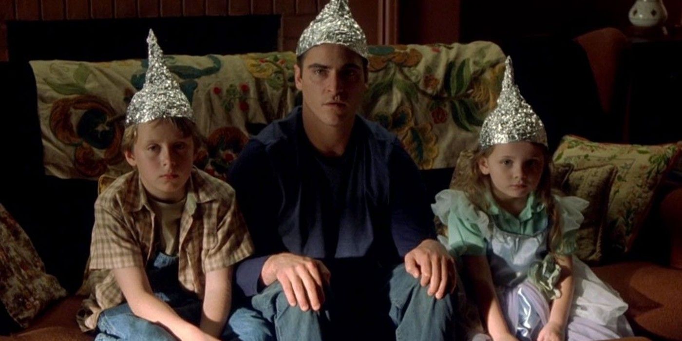 Sci Fi 2000s Signs protagonists looking at TV with tin foil hats