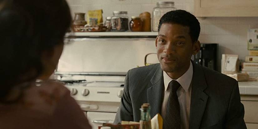 Will Smith sitting across from a woman in her kitchen in Seven Pounds