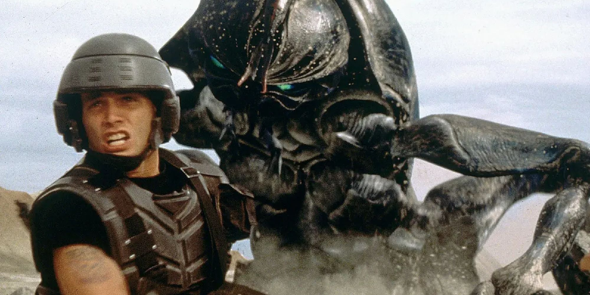 A soldier calling to someone as an insect monster charges at him in Starship Troopers
