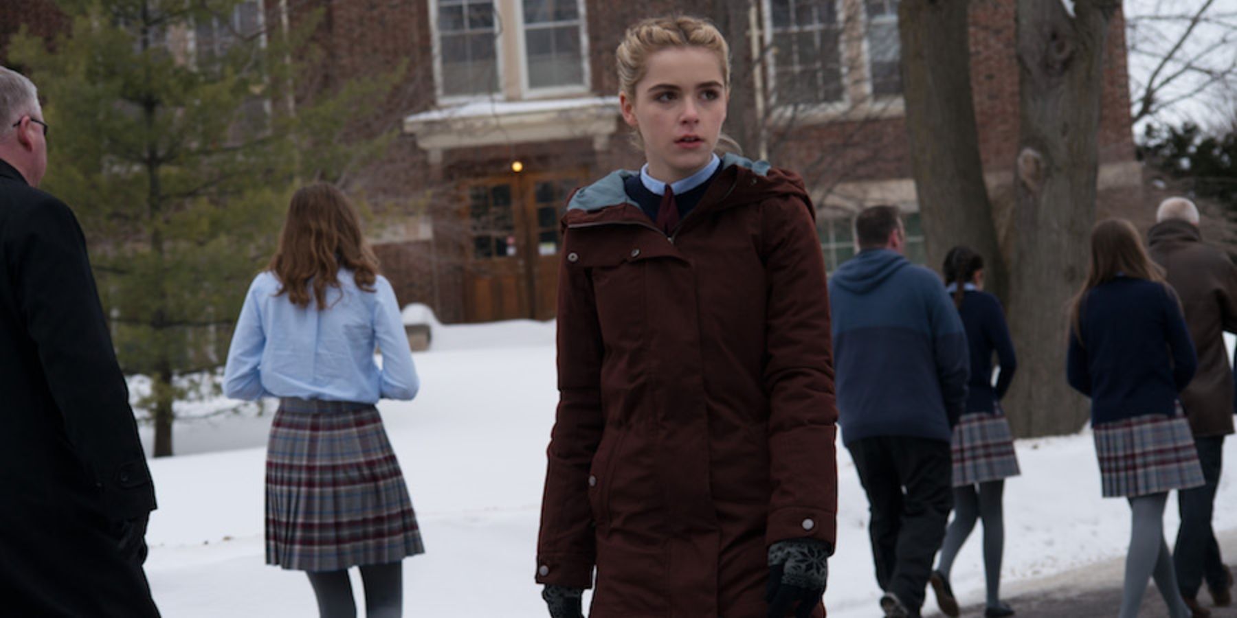 Kiernan Shipka as Kat standing outside boarding school in the snow in The Blackcoat's Daughter