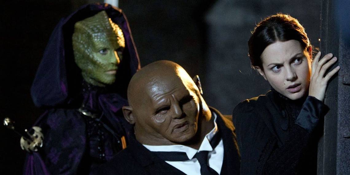 three people looking toward the right, two are aliens