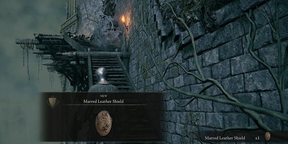 Player finding the Marred Leather Shield from Elden Ring.