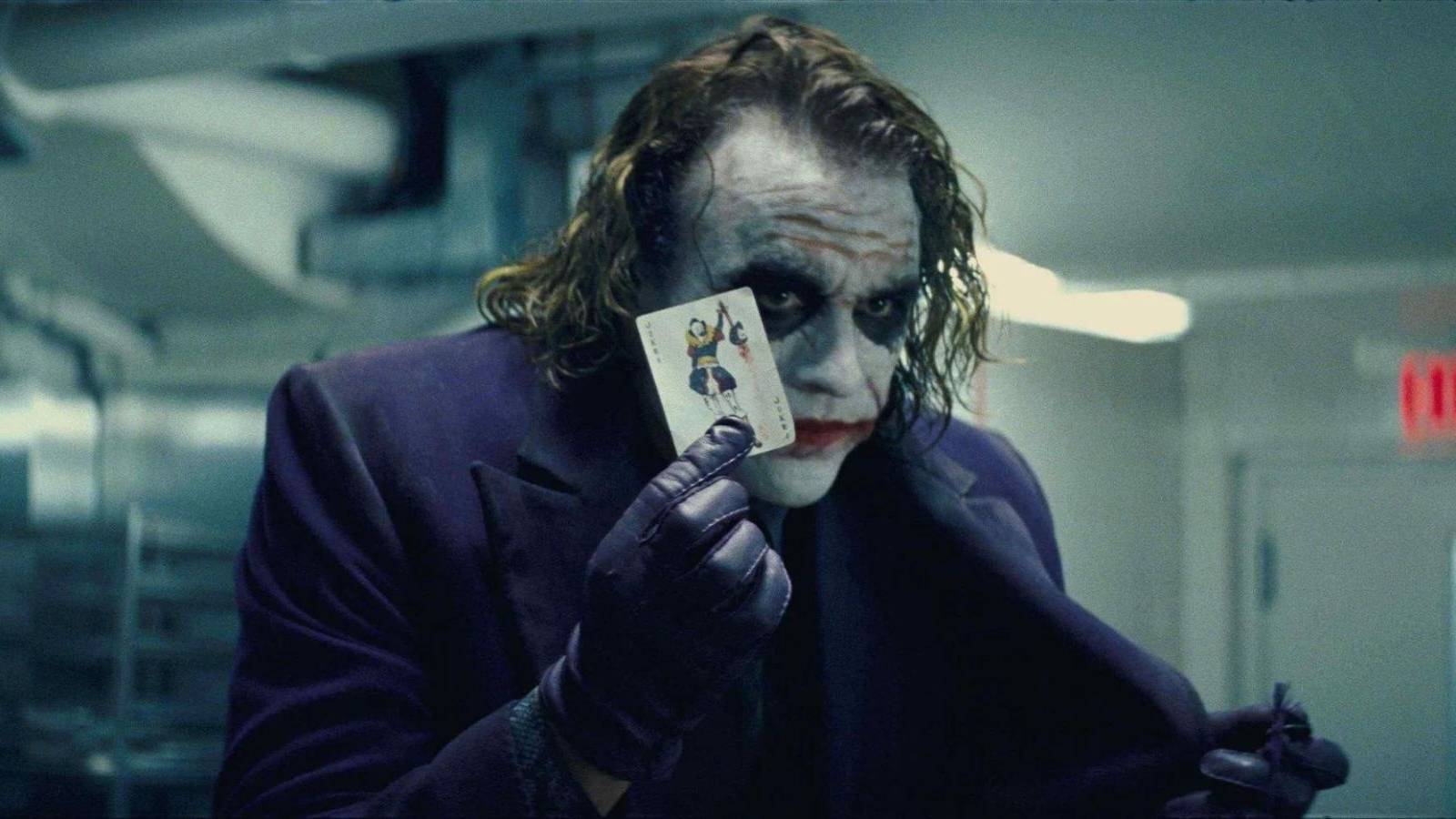 Heath Ledger holds up a Joker card in The Dark Knight
