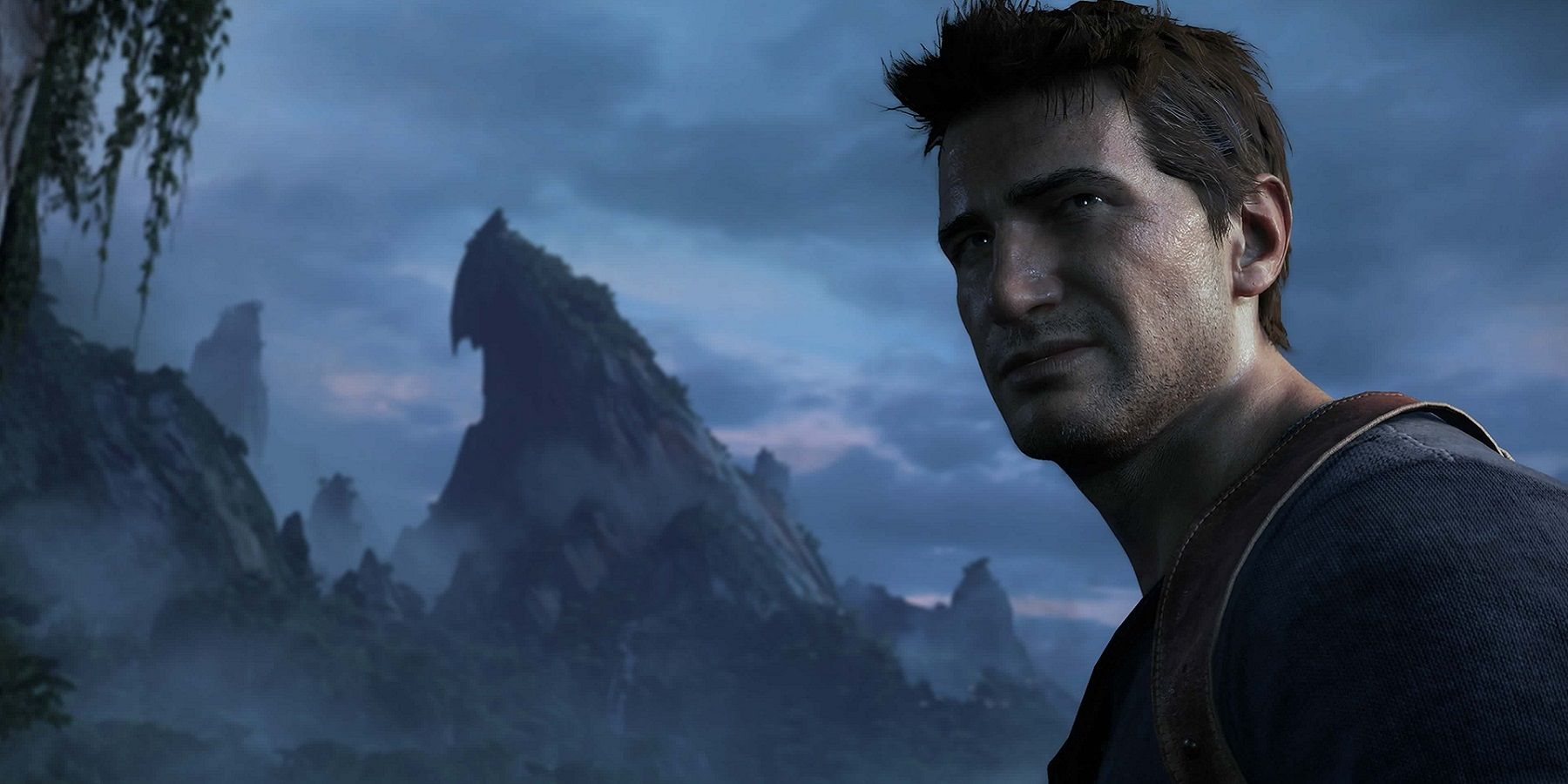 Image from Uncharted 4 showing Nathan Drake in the foreground with a gloomy mountain in the background.