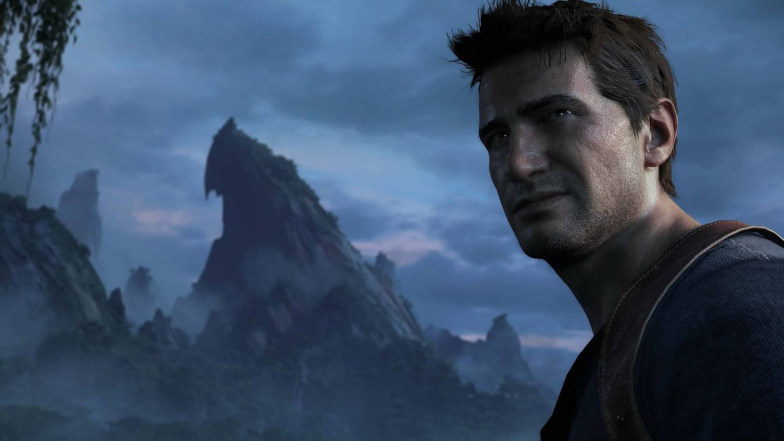 Image from Uncharted 4 showing Nathan Drake in the foreground with a gloomy mountain in the background.
