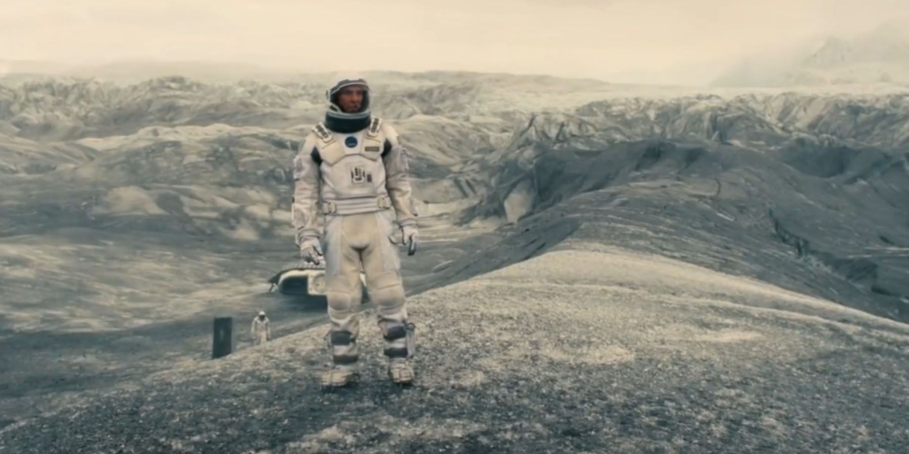 Interstellar astronaut standing on desolate mountainous planet
