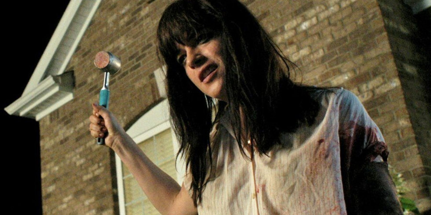 Selma Blair as Kendall holding up a hammer in Mom And Dad