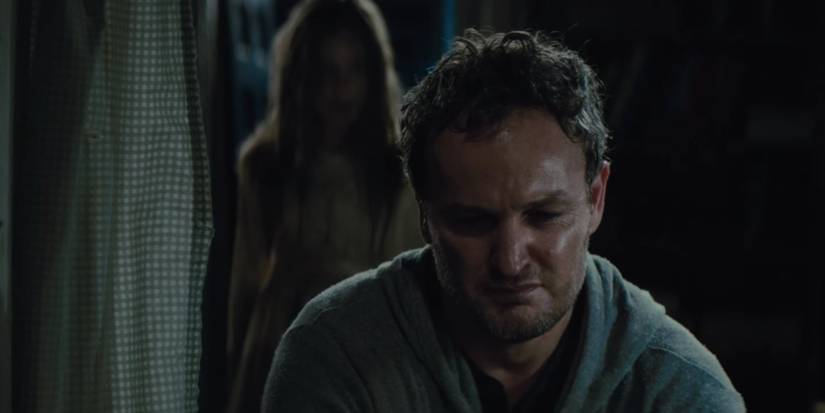 Ellie (Jeté Laurence) standing behind her dad Louis (Jason Clarke) in Pet Sematary (2019)