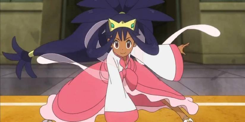 Iris in her Champions outfit striking a crouching pose during a battle