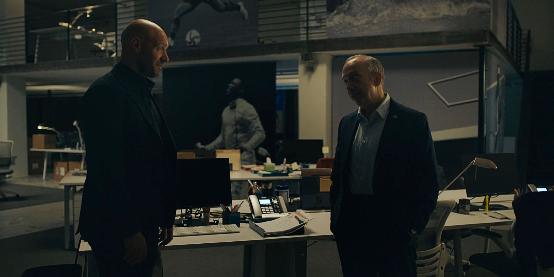 Michael Prince and Chuck Rhoades in dark office