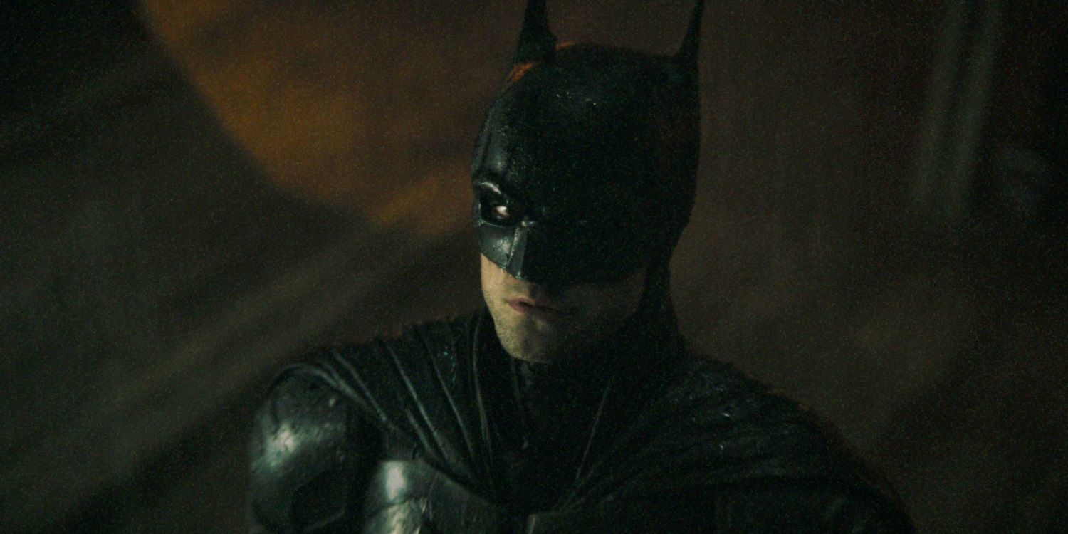 Robert Pattinson as Batman looking up in the rain