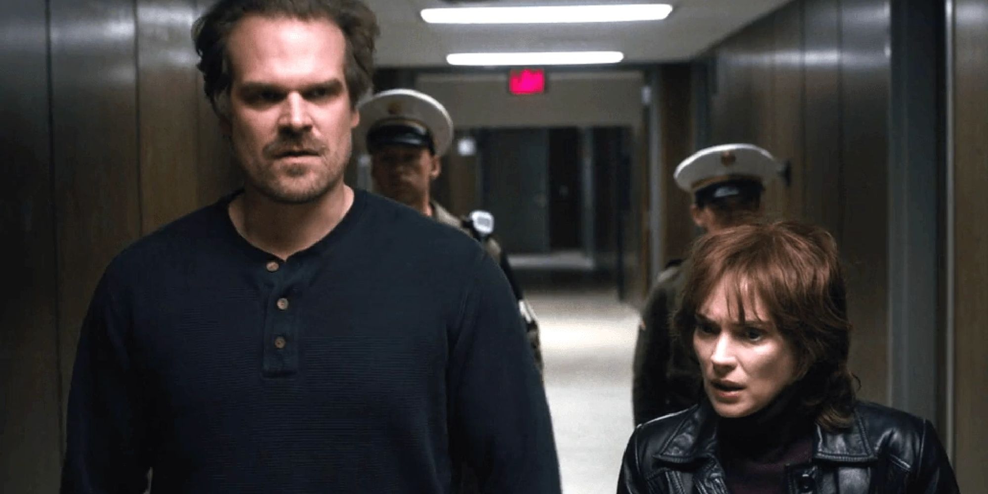 Joyce and Hopper being led down a hallway by security guards in season 1