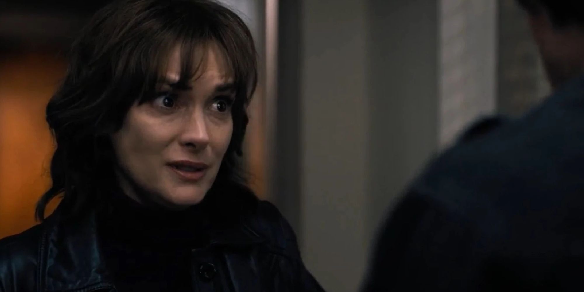 Joyce talking to Jonathan in the hallway of a police station in season 1