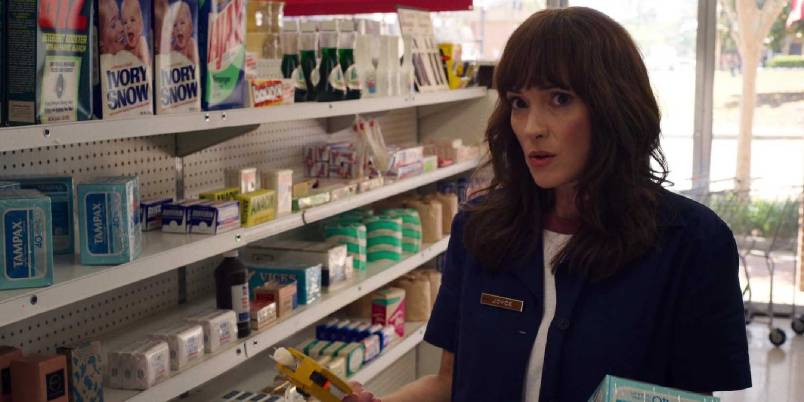 Joyce talking to Hopper while marking items for sale in season 3