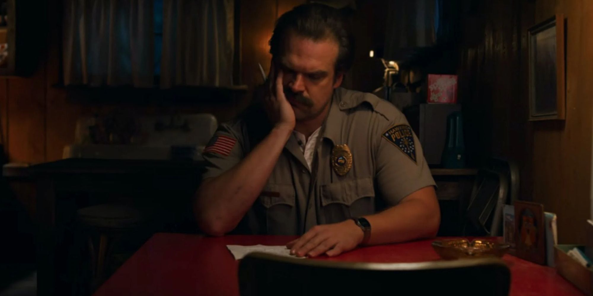 Hopper stares at the letter he's writing to Eleven and Mike