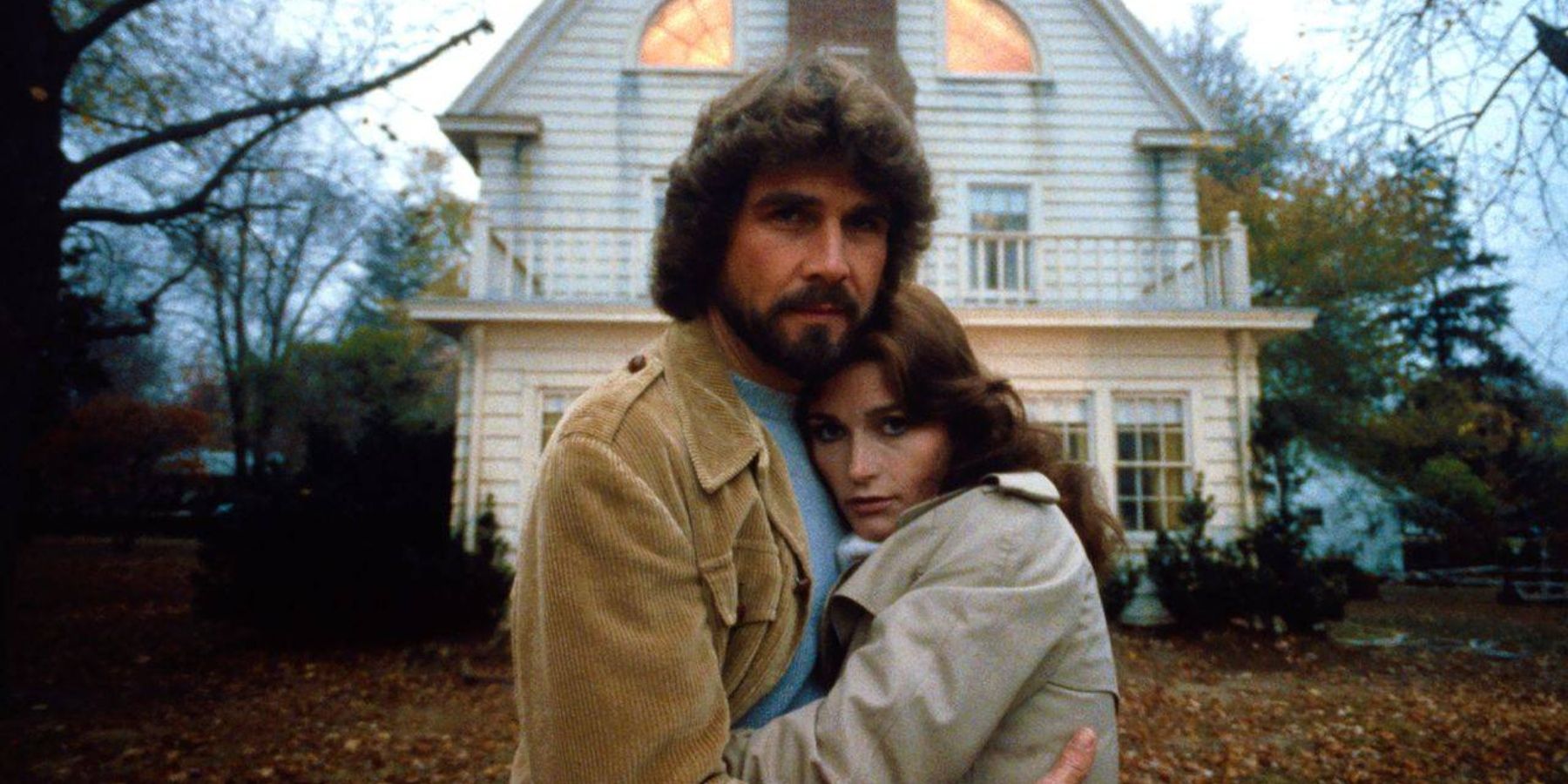 George (James Brolin) and Kathy Lutz (Margot Kidder) in front of the house in The Amityville Horror