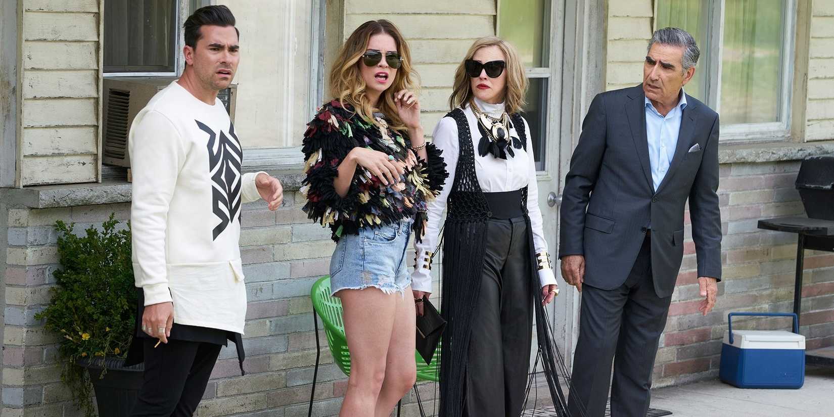 The Rose family standing outside the motel in Schitt's Creek