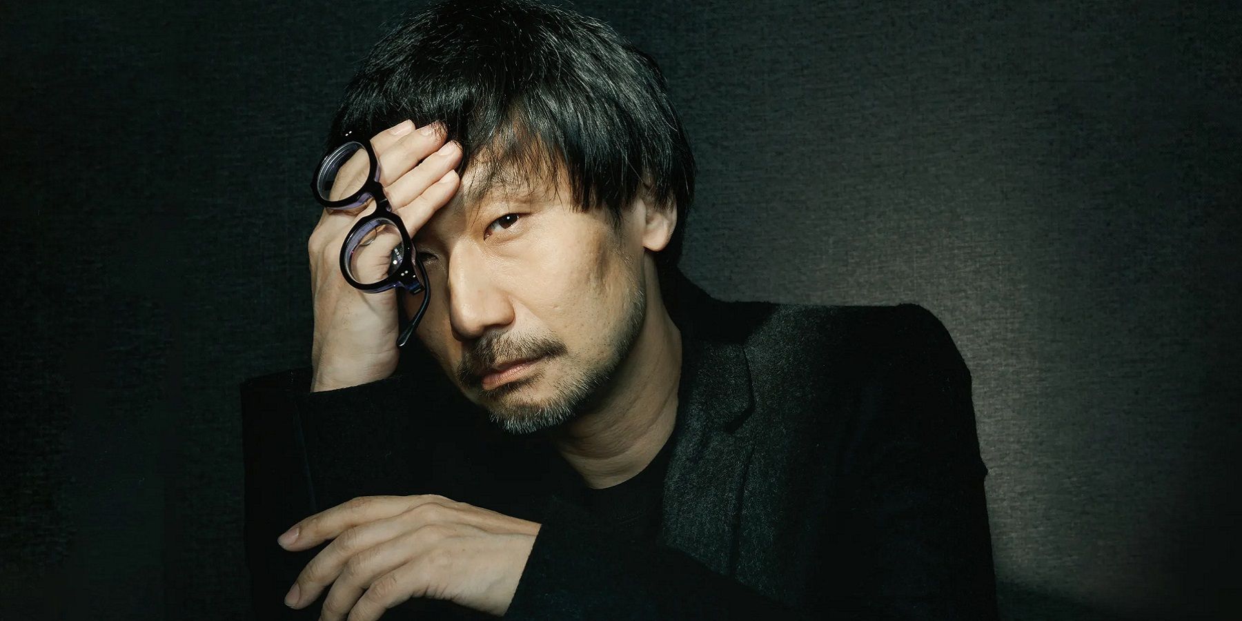 Photo of Hideo Kojima with his head in his hand.