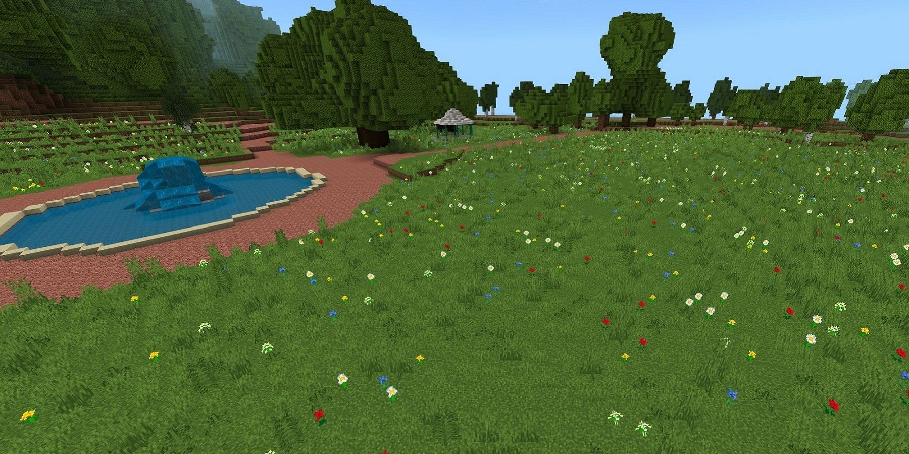 Image from the Rivercraft world in Minecraft, showing a field with a fountain to one side.