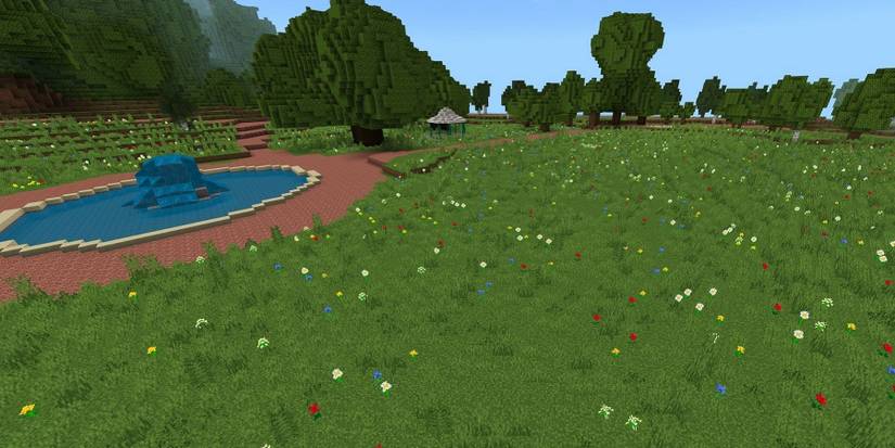 Image from the Rivercraft world in Minecraft, showing a field with a fountain to one side.