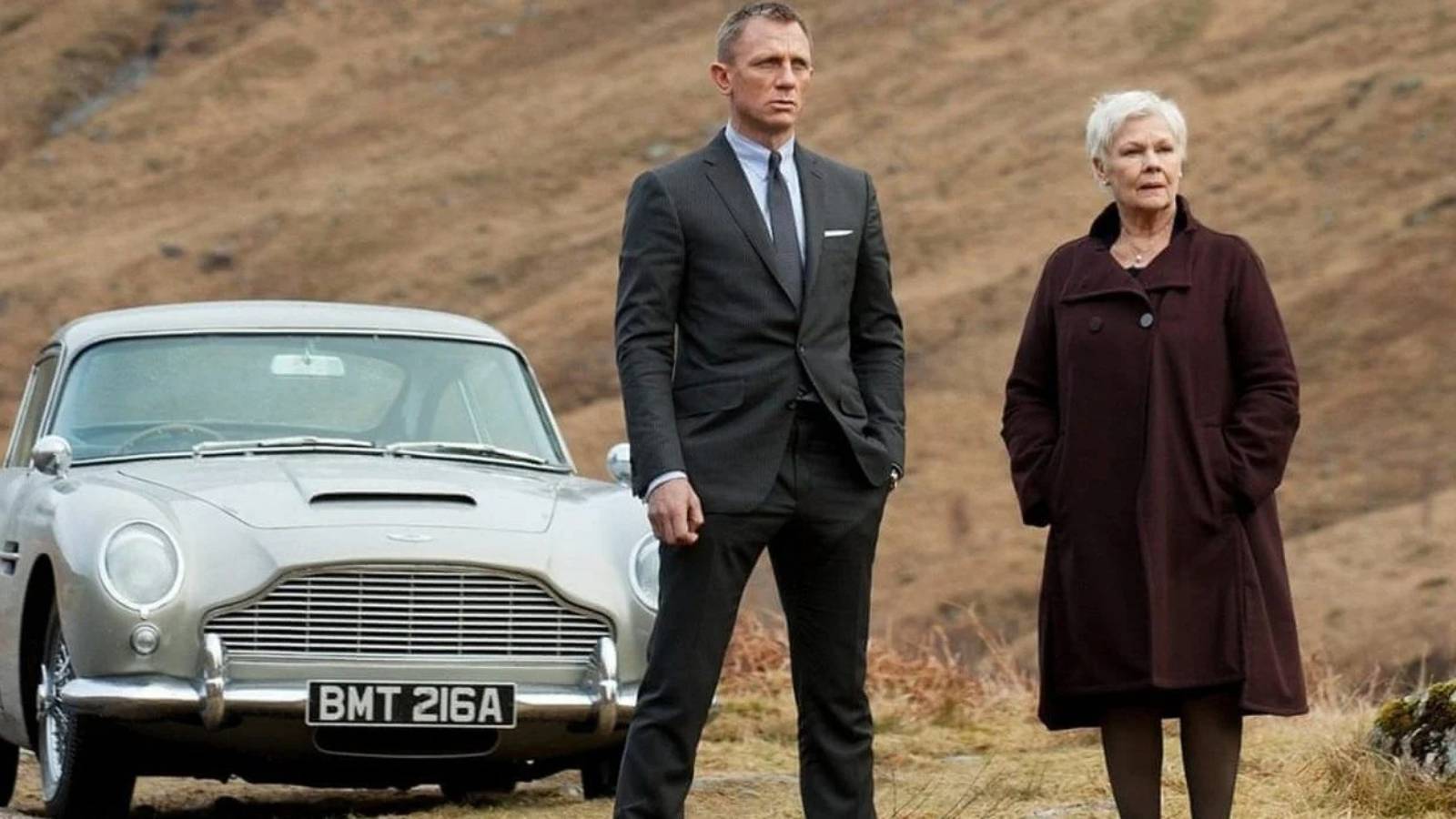 Daniel Craig and Judy Dench Bond and M next to Aston martin DB5