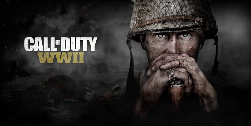 A battle-worn soldier stares forward with his hands resting on the stock of his weapon