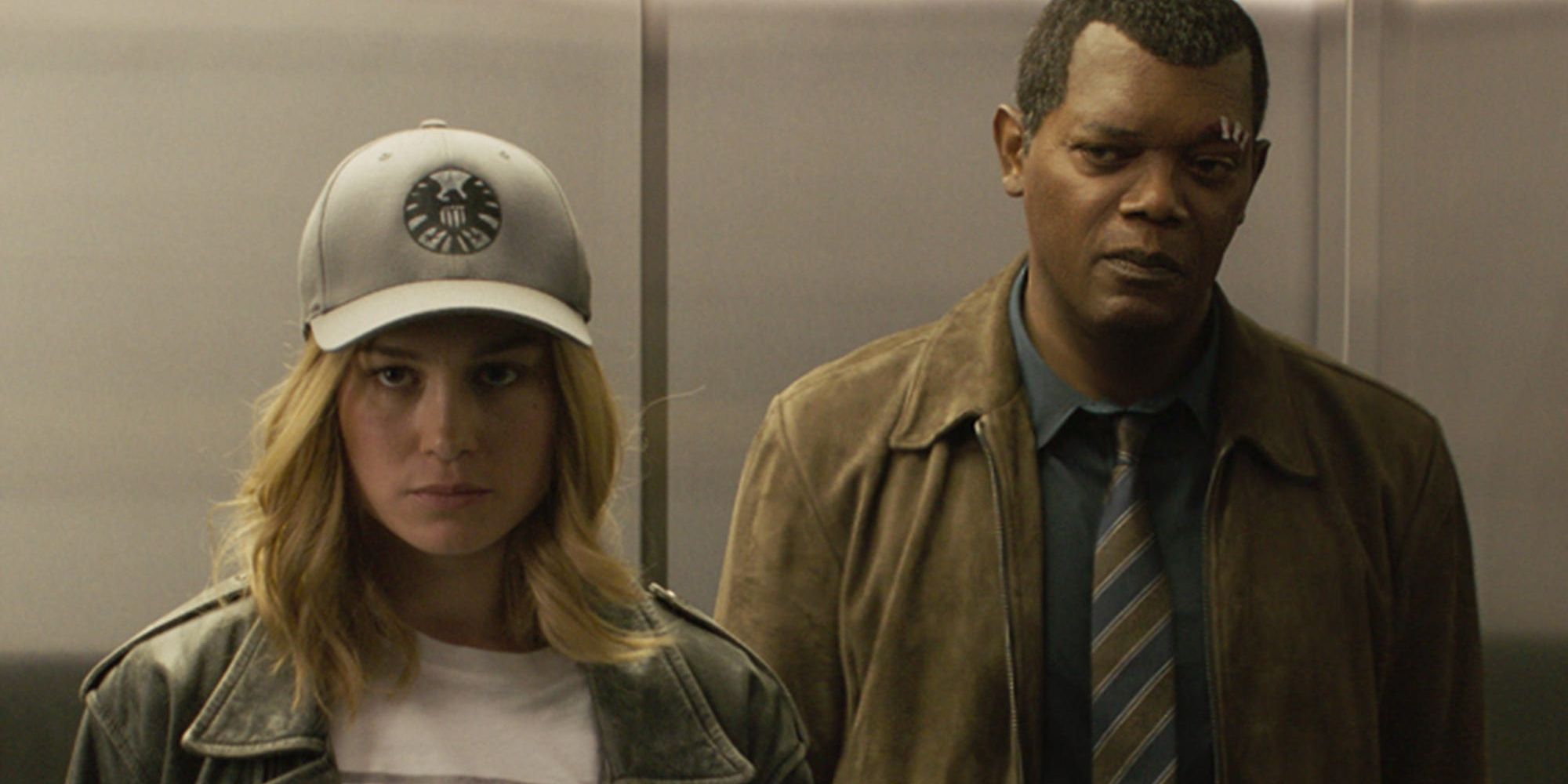 Nick Fury standing in an elevator with a disguised Carol Danvers in Captain Marvel