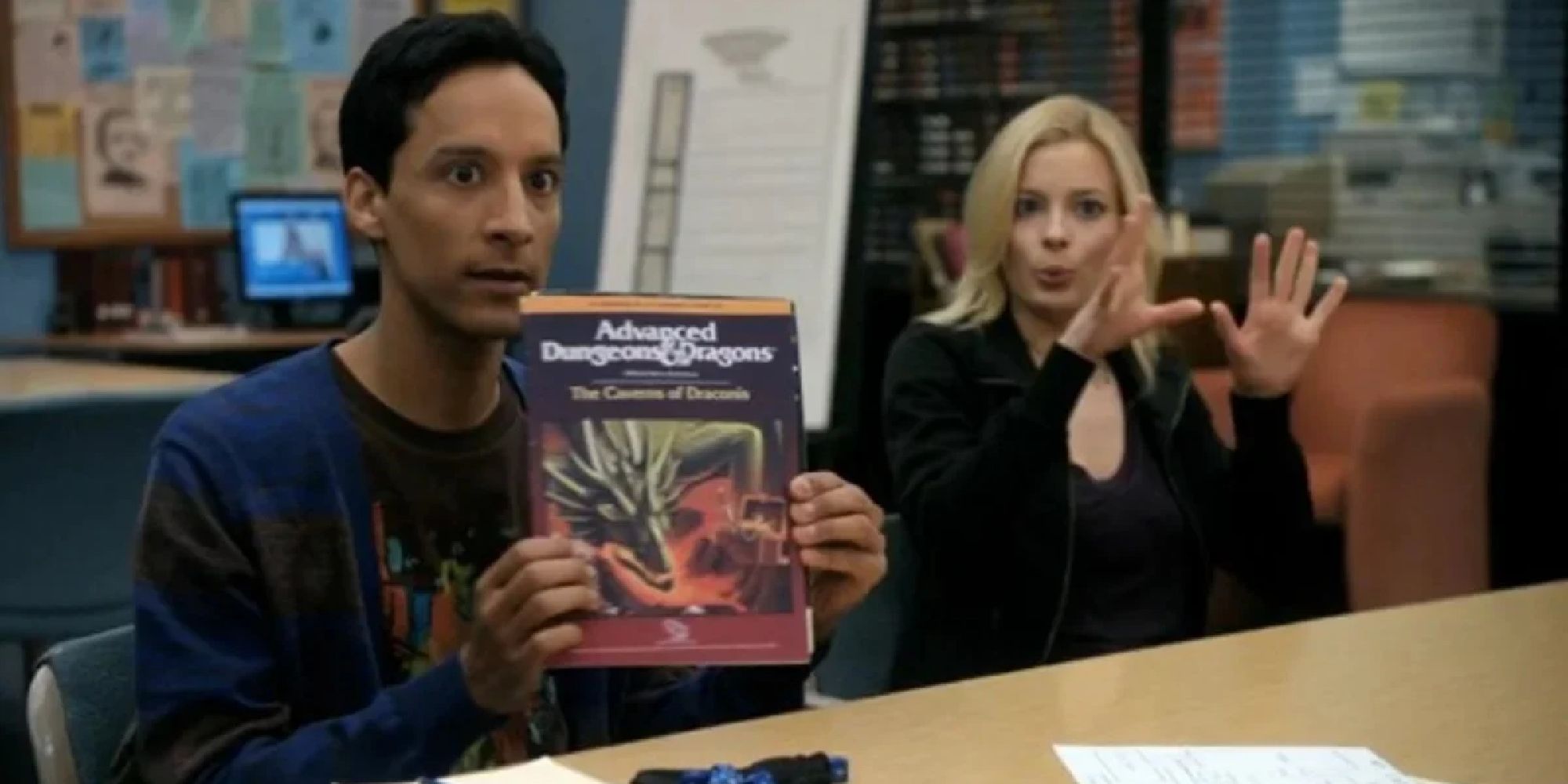 Abed holding up a Dungeons & Dragons book while sitting next to Britta in Community