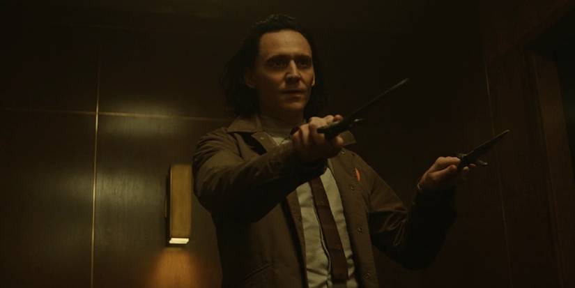 Loki aiming his dual knives at someone in the TVA hallway in Loki