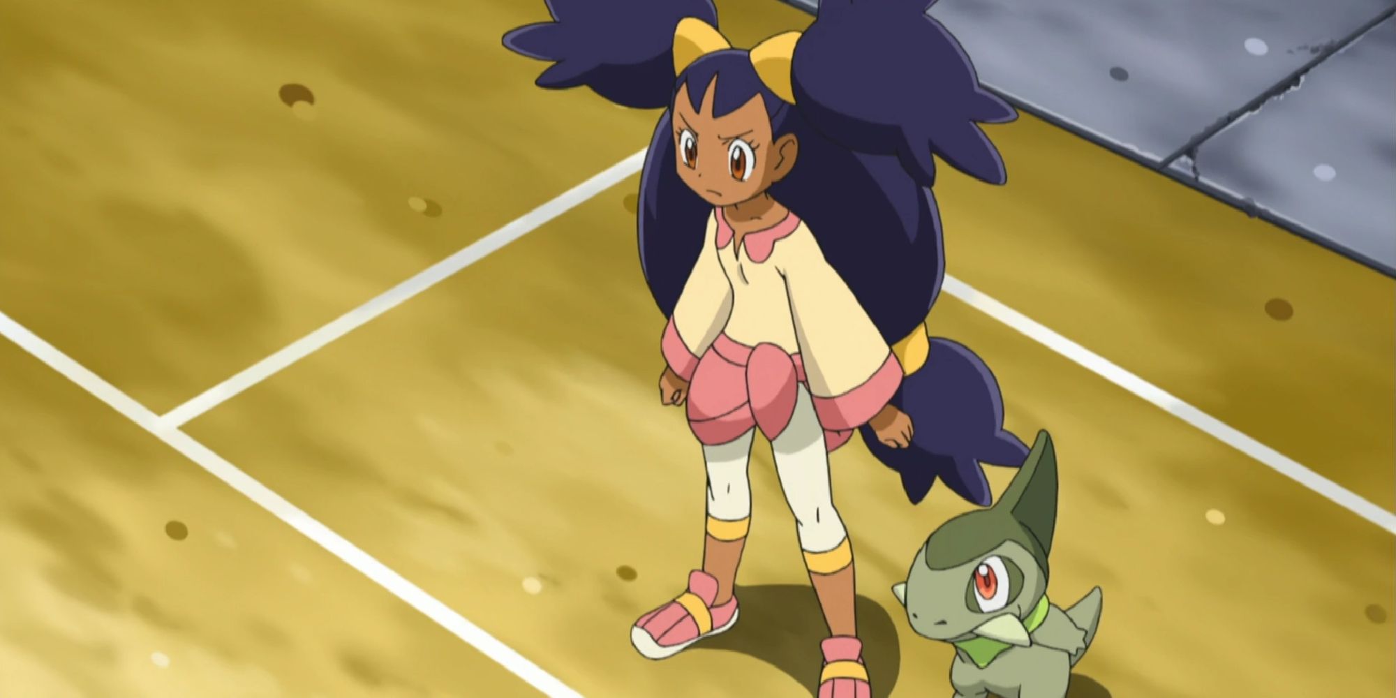 Iris and Axew on one end of a Pokemon gym court
