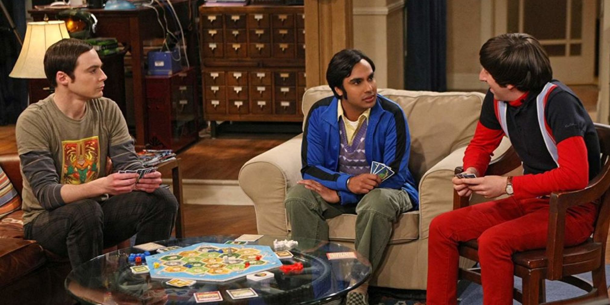Sheldon, Raj, and Howard in the middle of Settlers of Catan in Sheldon's apartment