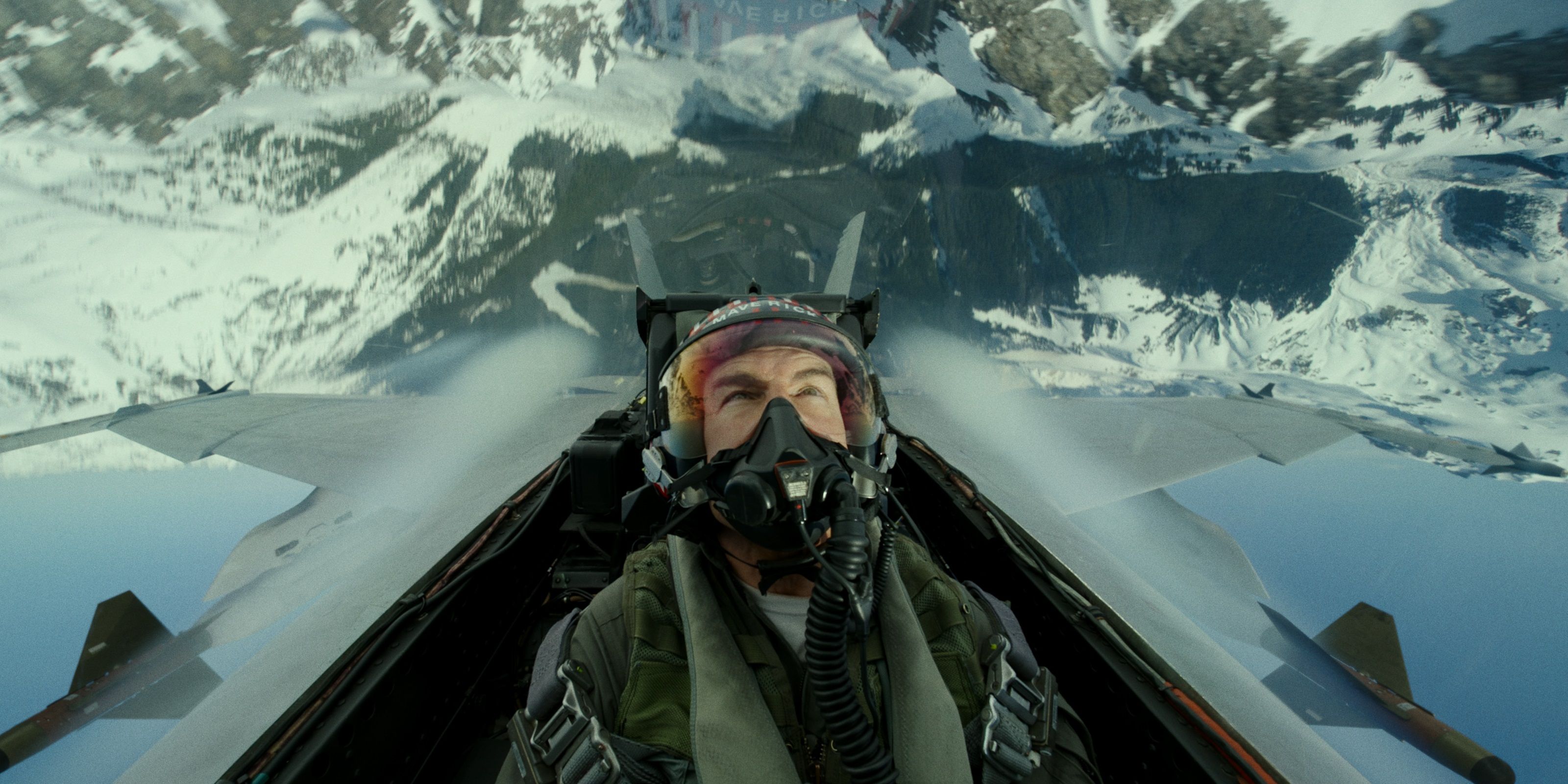 Tom Cruise flies over a mountain in Top Gun Maverick
