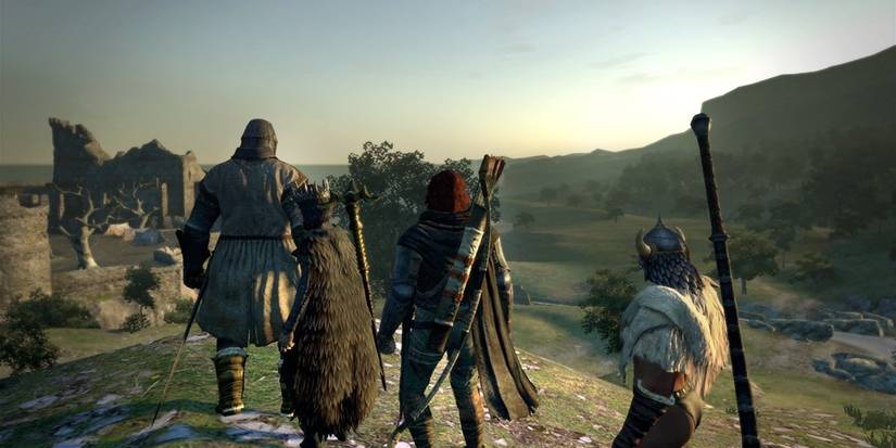 dragon's dogma Dark Arisen party looking over a cliff with a building in the background 