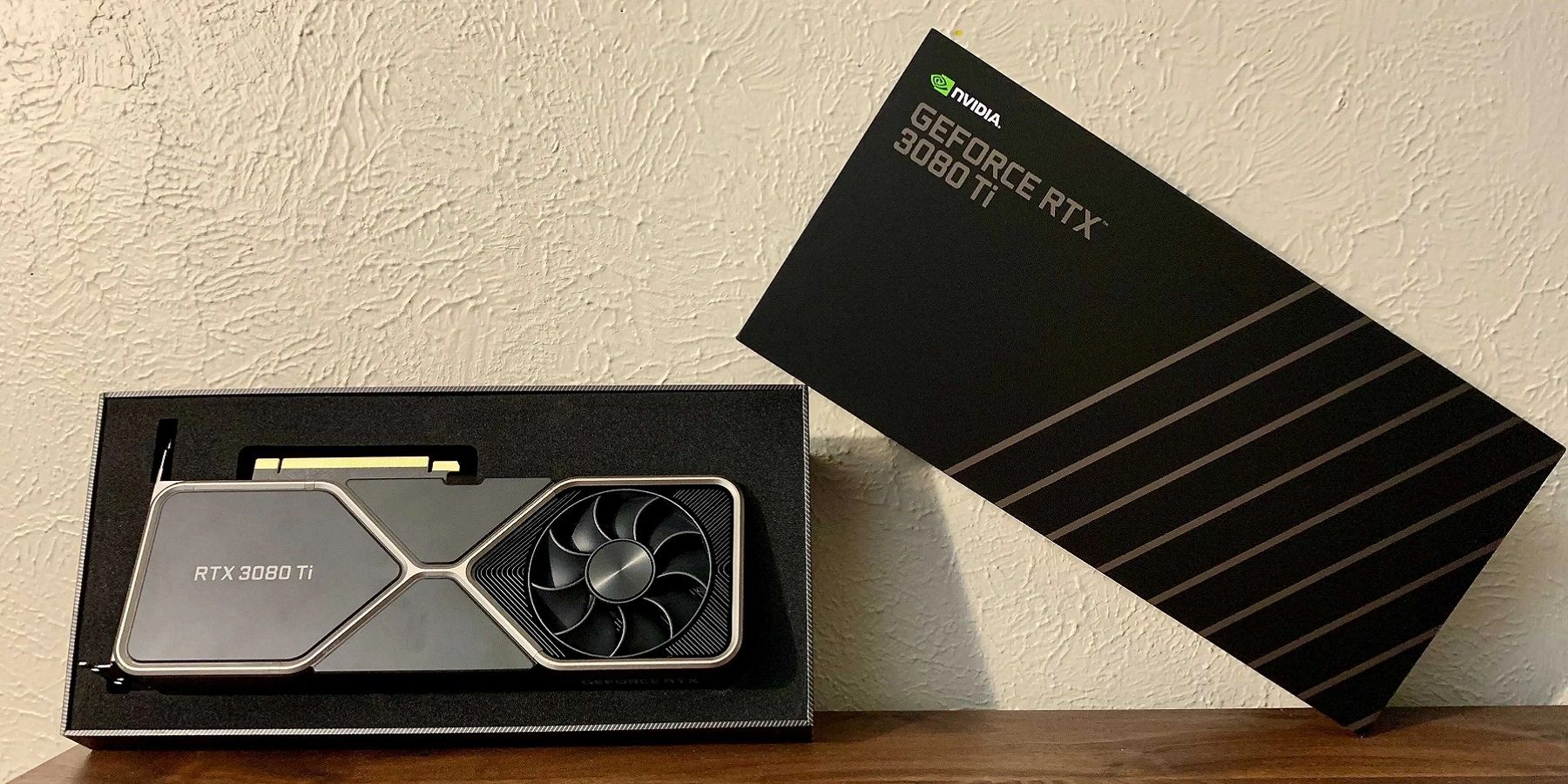 A picture of an Nvidia RTX 3080 Ti leaning up against a wall in its box.