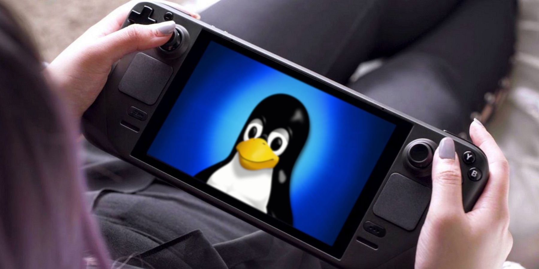 A photo of someone holding a Steam Deck which has the Linux penguin on the screen.
