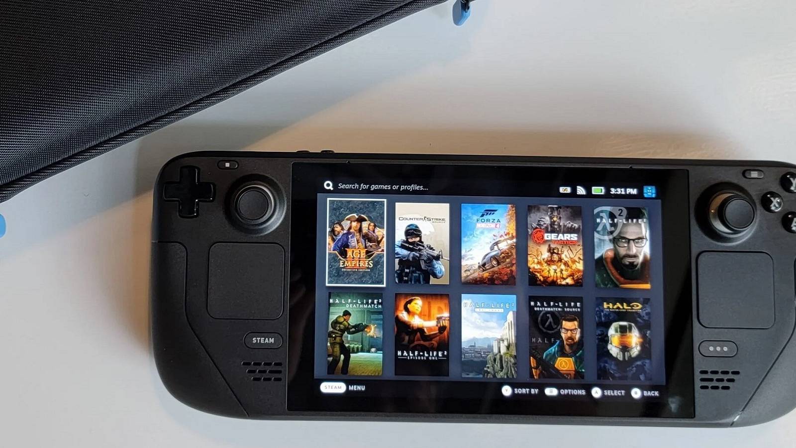 A photo of a Steam Deck next to an official carry case.